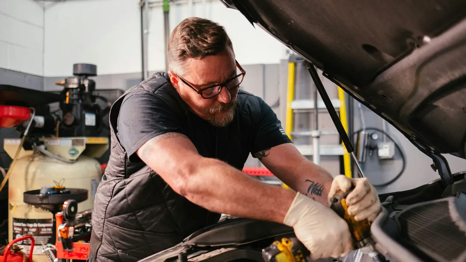 A mechanic working under the hood in his workshop
